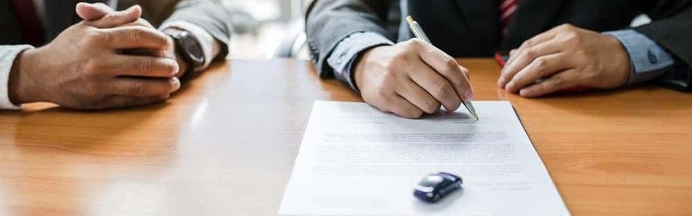 Close up of signing paperwork at a desk