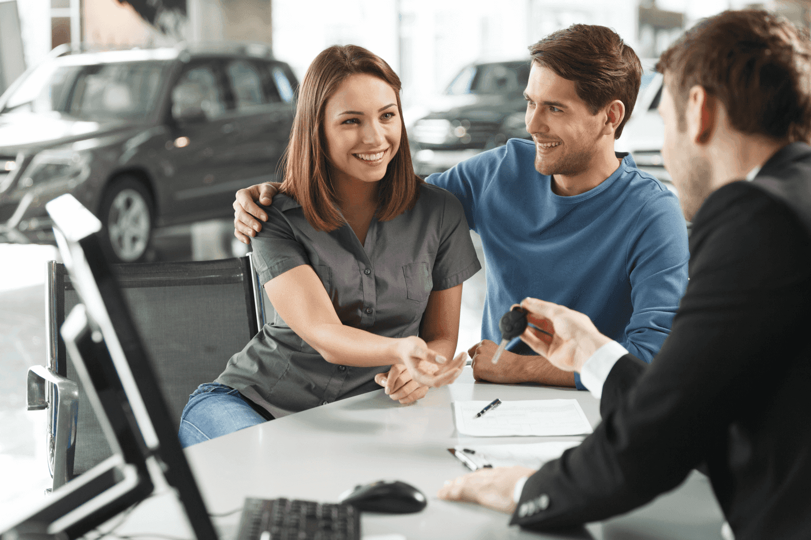 Couple at desk receiving keys from finance expert