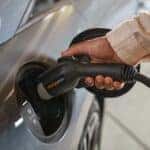 View of a person placing a charging cord into a charging port on the side of a 2025 Hyundai IONIQ 6