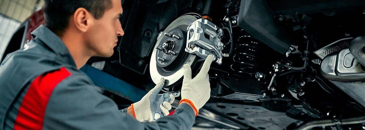 technician installing brake pads on a car