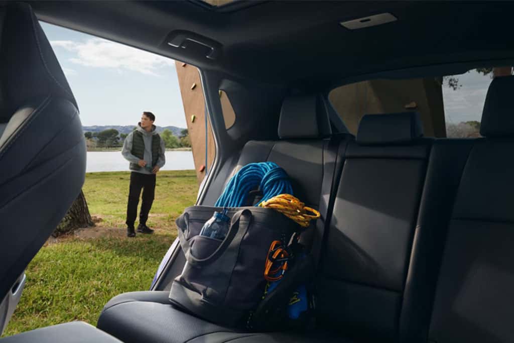 2026 Toyota bZ showing the backseats cargo with a person getting ready to rock climb with gear