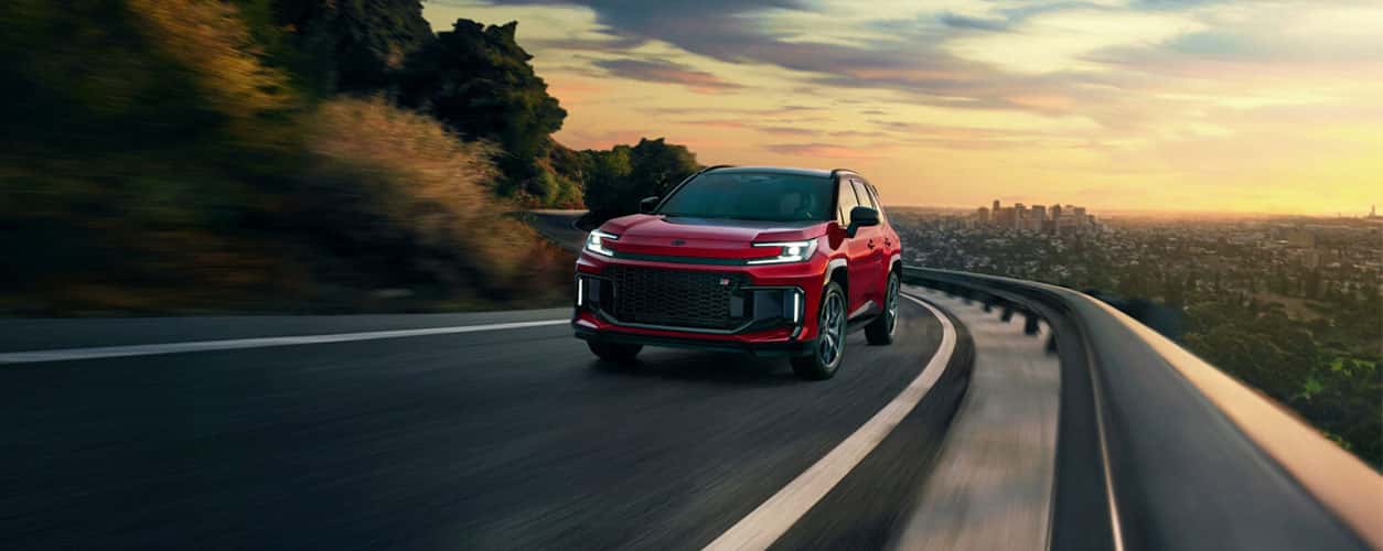 2026 Toyota RAV4 PHEV GR Sport racing down the road in red color with lights on