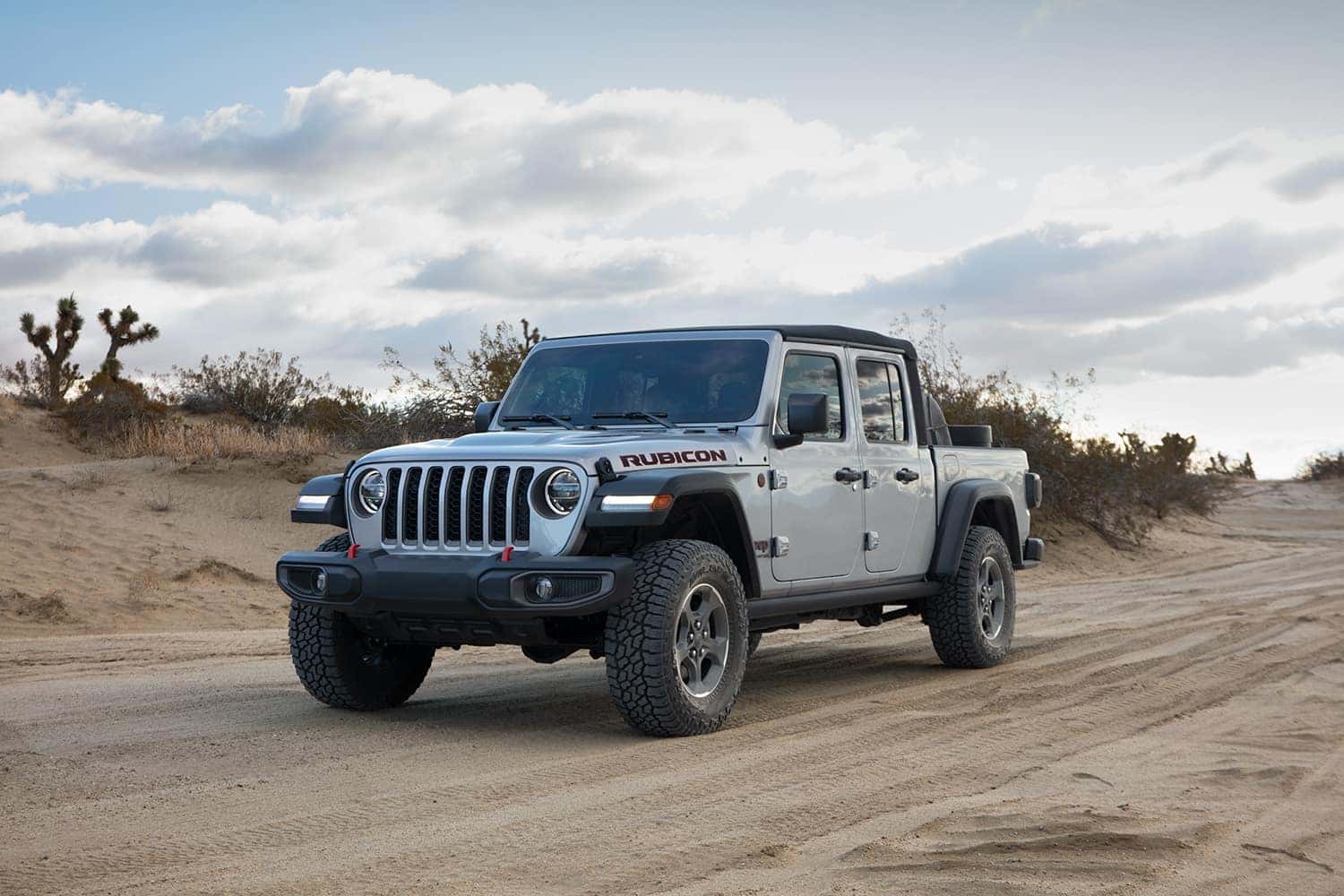 Compare the 2021 Jeep Gladiator vs. the 2021 Toyota Tacoma at Carolina Chrysler, Dodge, Jeep, and Ram | 2021 Jeep Gladiator parked in street