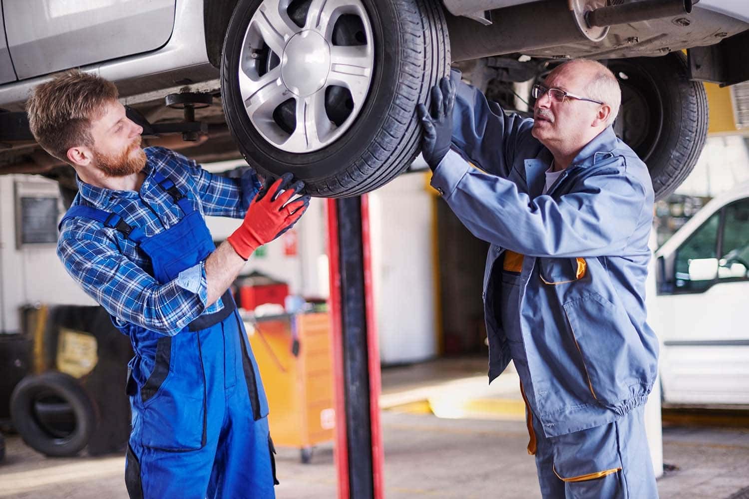 How to check your tires' health at Carolina Chrysler Dodge Jeep & Ram | Two mechanics changing tire on a vehicle
