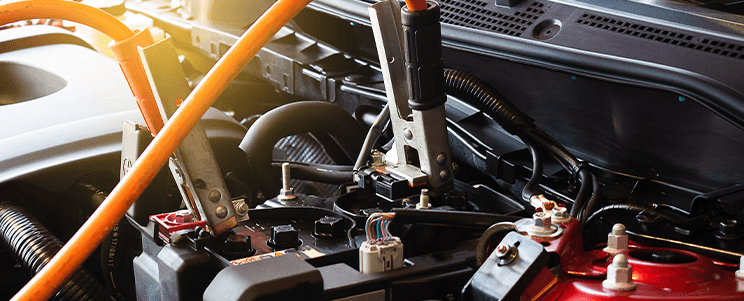 Everything You Need to Know about Your Car Battery at Carolina CDJR | Battery jumper cables connected to battery located in the engine bay