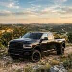 2026 Ram 3500 heavy-duty dually truck parked on a scenic ridge overlooking the rolling Texas Hill Country near Austin low-angle three-quarter view