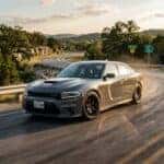 2026 Dodge Charger SIXPACK four door sedan in a high-gloss Destroyer Gray on a scenic road in the Texas Hill Country