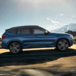 2020 bmw x3 blue exterior driving down scenic road