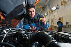 Technician checking fluid in a vehicle