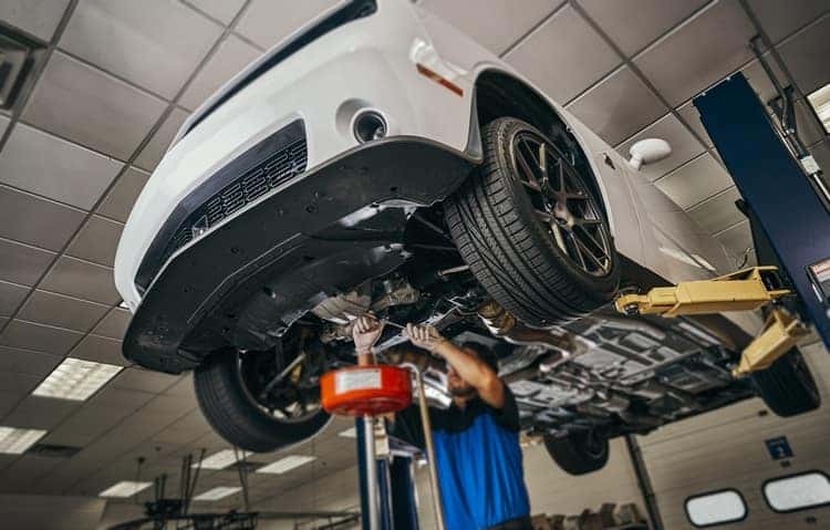 mechanic changing oil on a Dodge Challenger