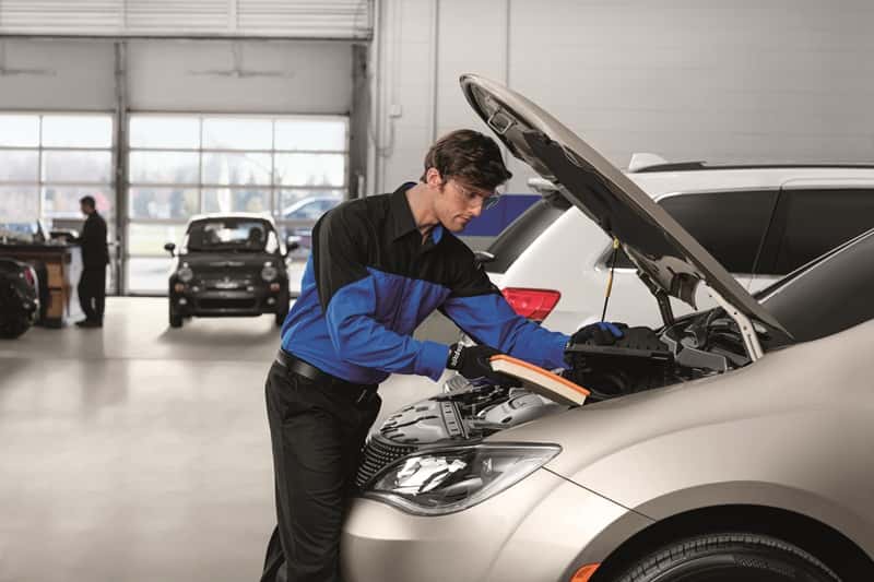 technician changing out the engine air filter on a Chrysler Pacifica