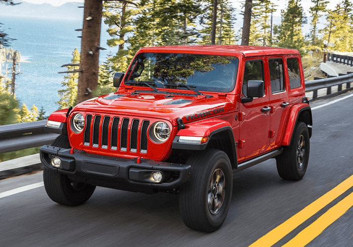 Red Used Jeep Wrangler driving on the road