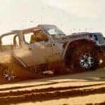 2020 Jeep Wrangler driving off road in a cloud of dust