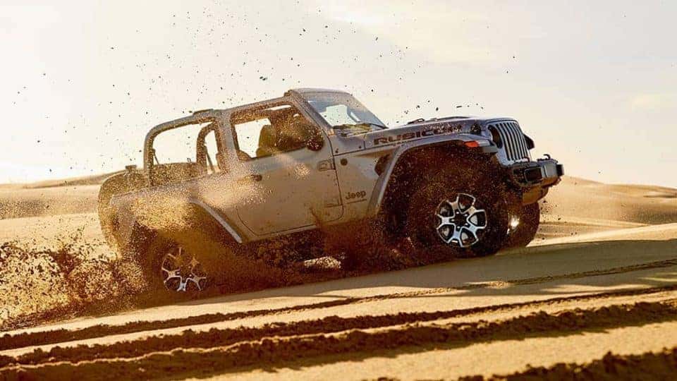 2020 Jeep Wrangler driving off road in a cloud of dust