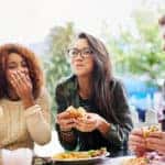 Cropped shot of three friends eating burgers