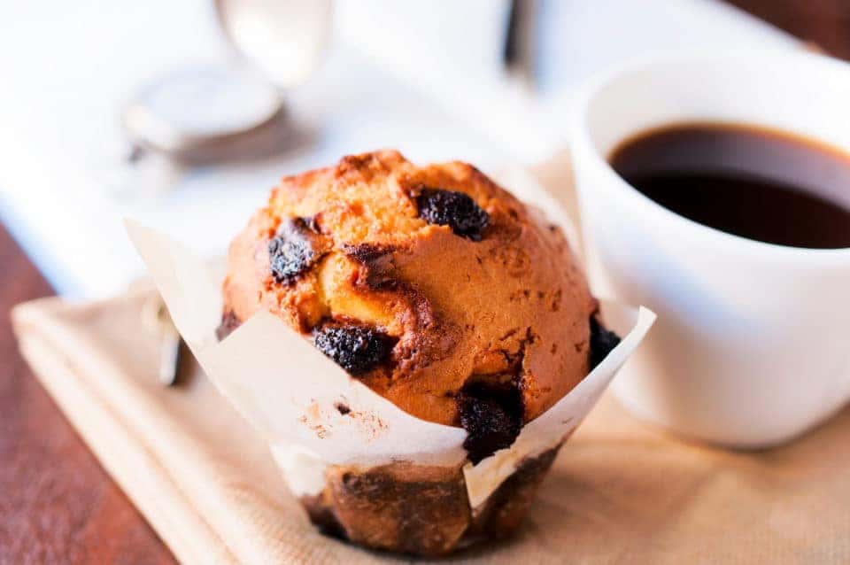 Blueberry muffin with coffee in a white mug