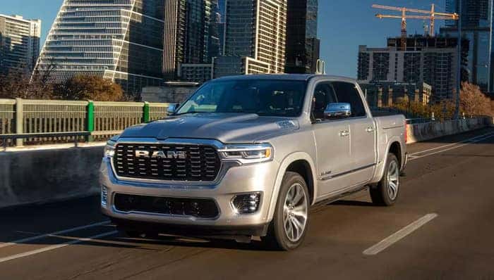 Silver Ram 1500 driving down street