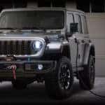 Jeep Wrangler 4xe charging in front of a house