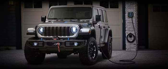 Jeep Wrangler 4xe charging in front of a house