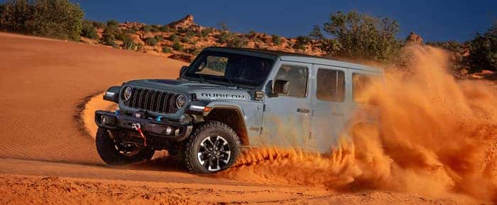 Gray Jeep Wrangler driving in the sand