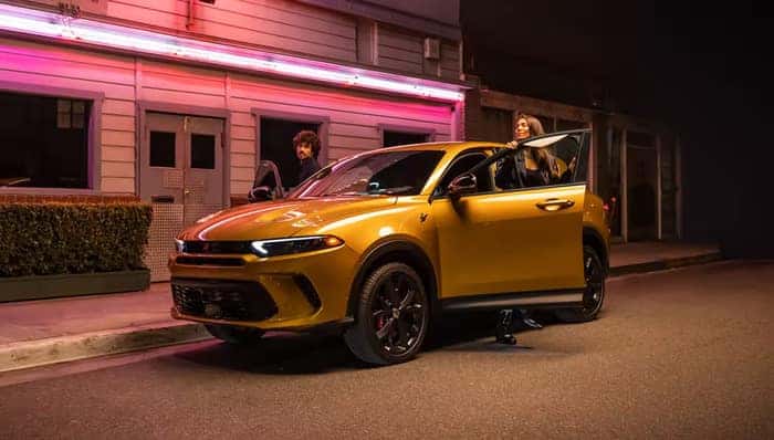 Gold Dodge hornet parked on the side of the road