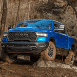 Blue 2025 Ram 1500 driving over rocks