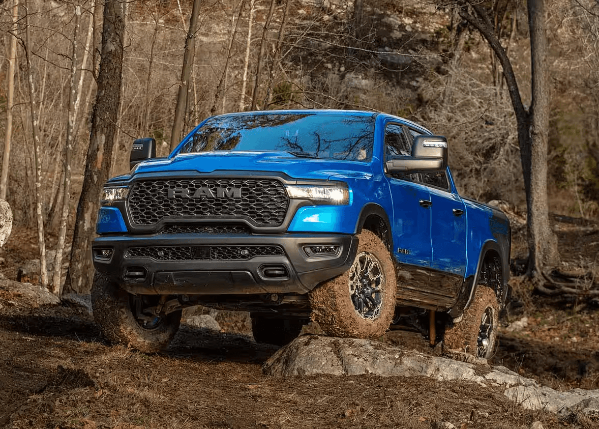 Blue 2025 Ram 1500 driving over rocks