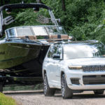 White 2025 Jeep Grand Cherokee towing a boat