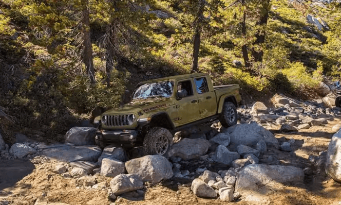 Green 2025 Jeep Gladiator Rubicon driving over rocks