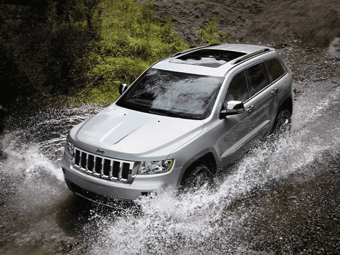 Gray Jeep Grand Cherokee driving through water