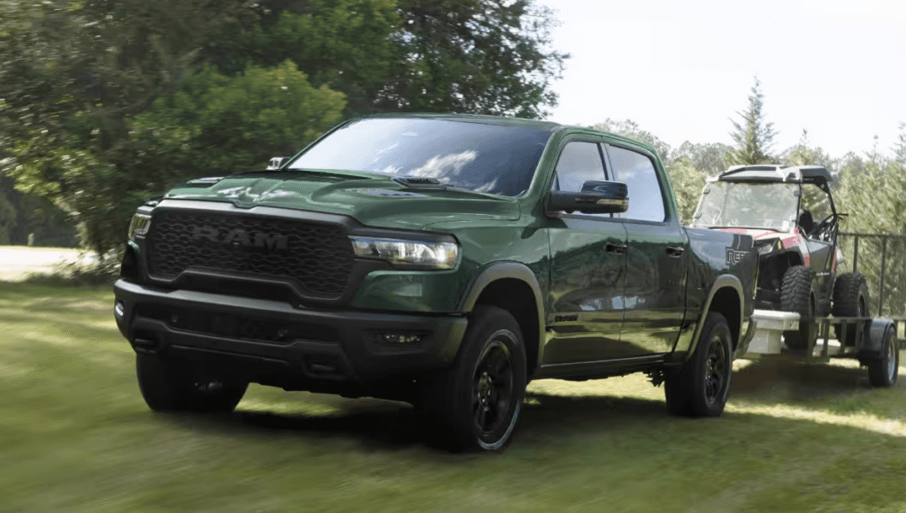 Green 2026 Ram 1500 Rebel towing a vehicle