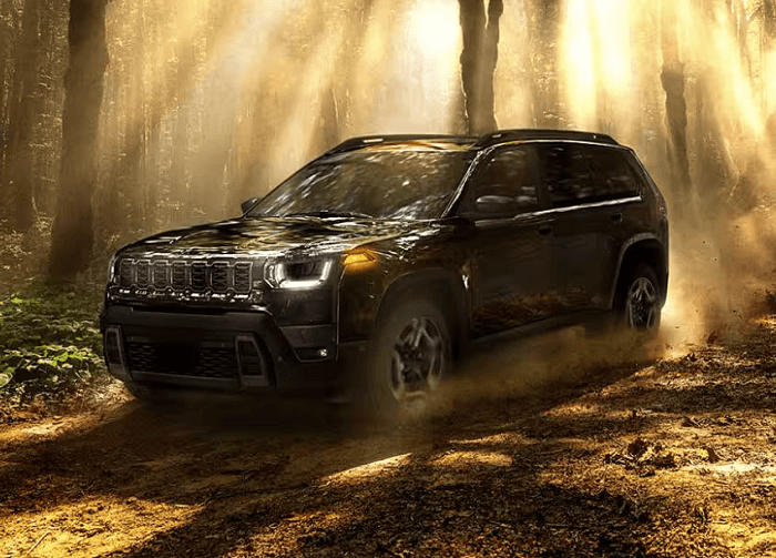 Black 2026 Jeep Cherokee driving off-road.