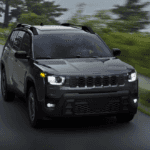 Black 2026 Jeep Cherokee driving on road