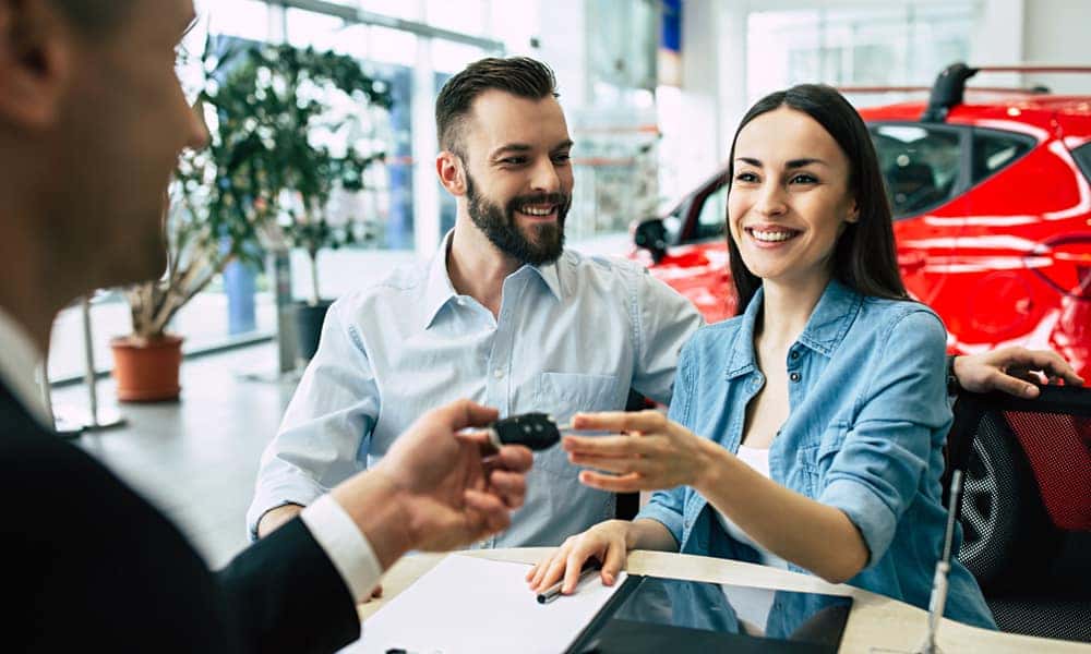 couple accepting keys after purchasing a vehicle