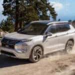 white Mitsubishi Outlander PHEV driving on the dirt
