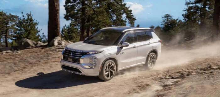white Mitsubishi Outlander PHEV driving on the dirt