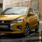 Yellow 2024 Mitsubishi Mirage driving in the rain