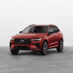 Front three-quarter view of a red 2025 Volvo XC60 in a clean studio setting, emphasizing its sporty exterior styling.
