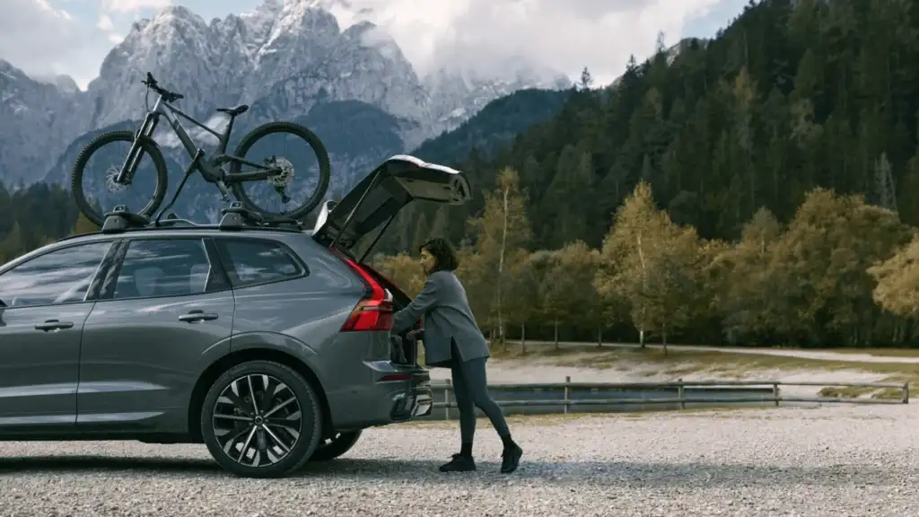 2025 Volvo XC60 SUV with open tailgate and roof-mounted bicycle, highlighting exterior design choices and versatility.
