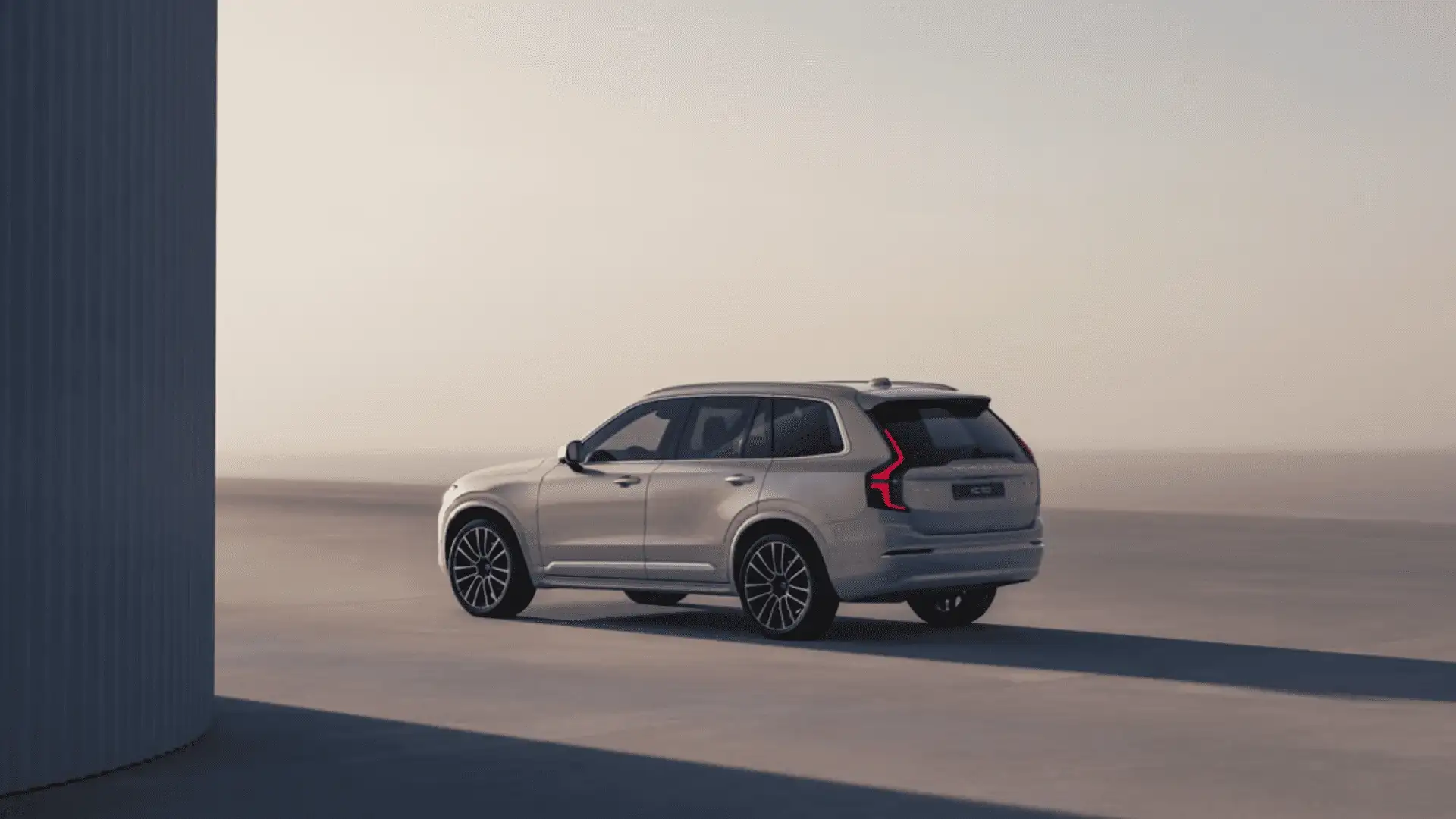 Rear view of the 2025 Volvo XC90 in a clean urban setting near Bristol, TN, showcasing its elegant design, large cabin space, and signature Volvo taillights.