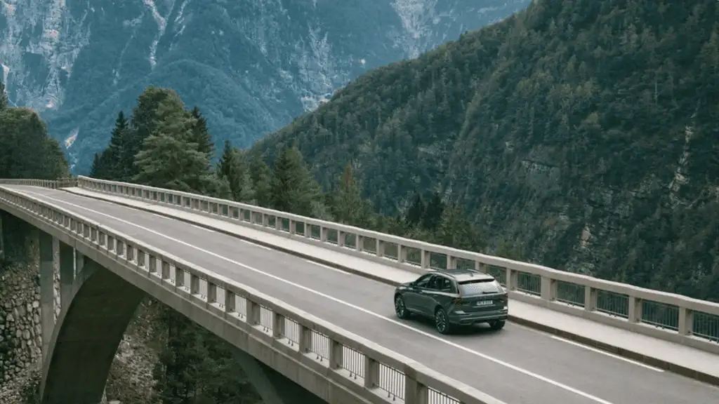 2026 Volvo XC60 driving through scenic mountains, highlighting the enhanced Volvo Car UX system for a smarter, connected driving experience.