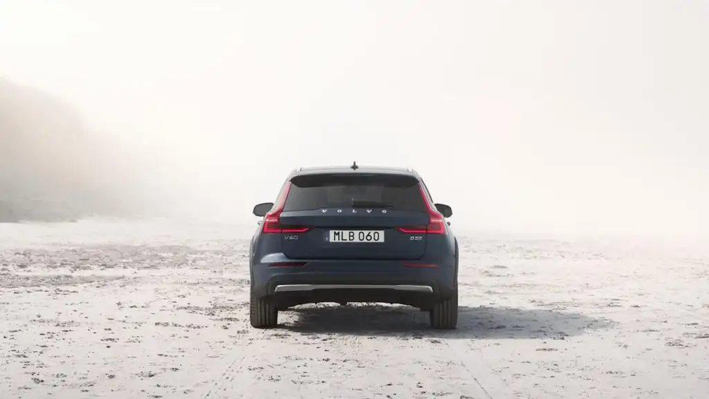 Rear exterior view of the 2026 Volvo V60 Cross Country parked on a rugged landscape, highlighting taillights, stance, and all-road capability.