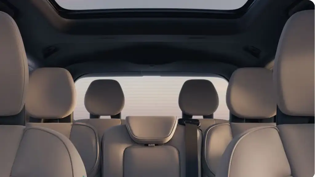 Interior rear seating of the 2026 Volvo XC90 showing spacious passenger layout, headrests, seatbelts, and panoramic roof for comfort-focused travel.