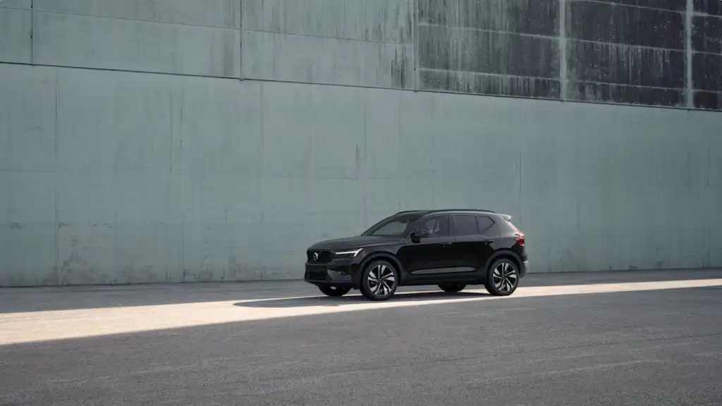 2026 Volvo XC40 parked beside a modern concrete wall, featuring compact SUV design and confident winter driving capability for Bristol, TN commuters.