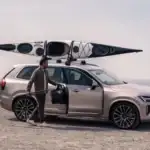 2026 Volvo XC90 Plug-In Hybrid AWD parked near the coast with a kayak on the roof, highlighting weekend travel and outdoor capability for Bristol, TN drivers.