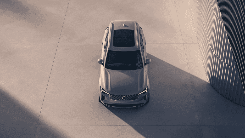 Top-down view of a 2026 Volvo XC90 Plug-In Hybrid parked in a modern architectural space, highlighting panoramic roof and luxury SUV design.