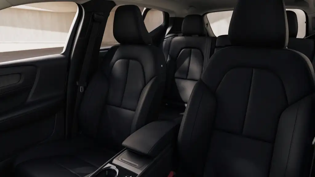 2026 Volvo XC40 interior showing front and rear black leather seating with armrest and ample passenger space