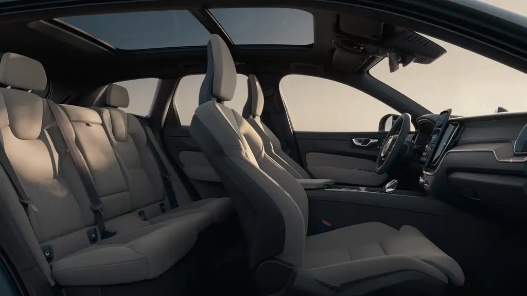 2026 Volvo XC60 interior showing front and rear premium beige leather seating with panoramic sunroof and Scandinavian cabin design