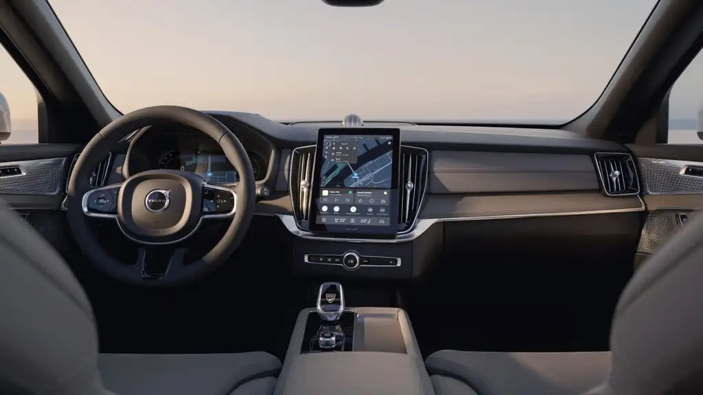 2026 Volvo XC90 Plug-in Hybrid interior dashboard with vertical touchscreen infotainment display, Volvo steering wheel, and premium beige cabin trim