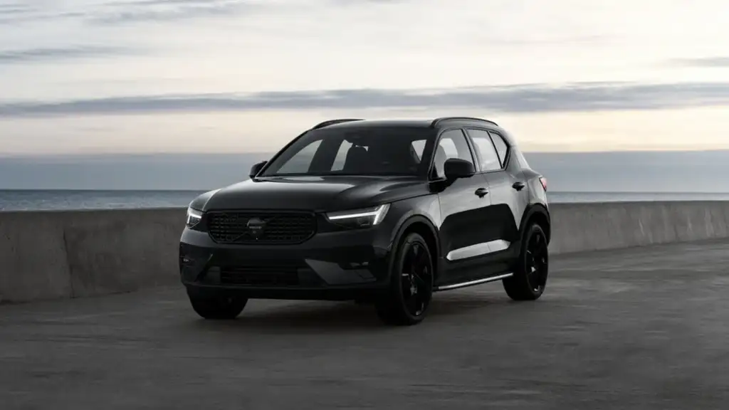 2026 Volvo XC40 in all-black with LED headlights parked on a waterfront road at dusk, highlighting safety features for Johnson City TN drivers